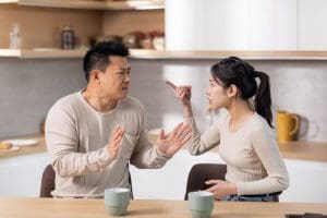 Spouses in a heated discussion at home, representing marriage differences and the need for humility, charity, and understanding in relationships.