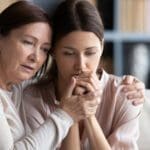 Mother comforting her adult daughter during divorce, showing family support, stress management, and the importance of protecting children during family upheava