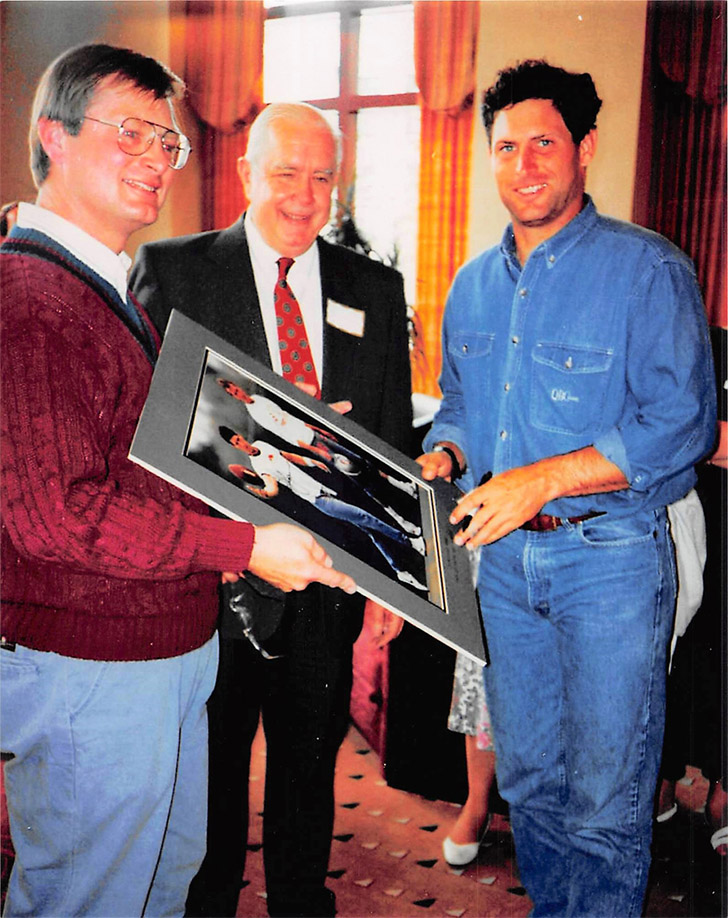 Steve Young with city officials holding a framed photo of his iconic Kirtland Temple shirt appearance alongside Joe Montana.