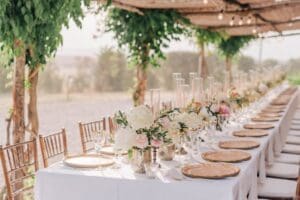 Elegant outdoor wedding reception table with floral centerpieces, representing a family gathering.