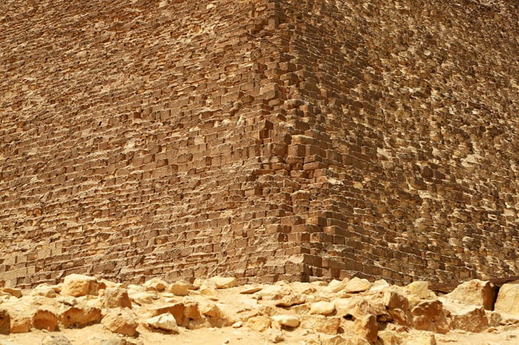 A close-up view of the massive limestone blocks used to construct the Great Pyramid, revealing the precision and scale of ancient engineering.