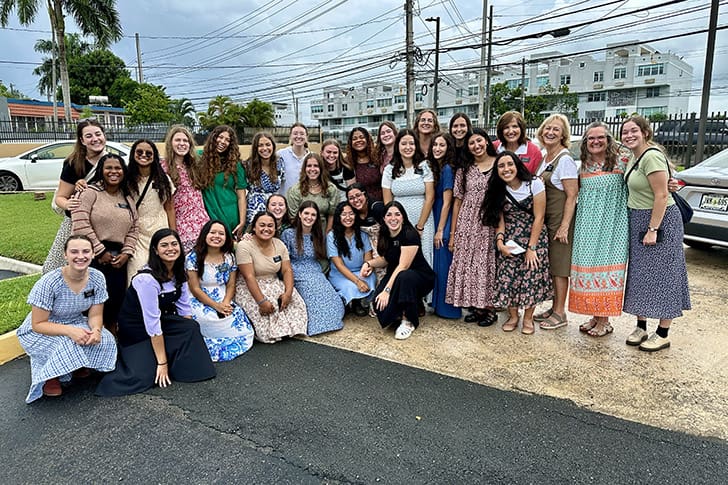 Maurine with a large group of LDS sister missionaries gathers outside, embodying the unity and strength found in missionary service