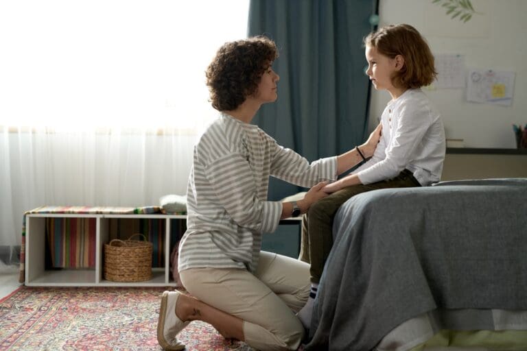 Mother having a serious conversation with her daughter in a bedroom.