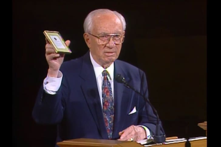 President Gordon B. Hinckley holds a framed widow's mite as a reminder of sacred funds and the sacrifice of the poor in paying tithes and offerings.