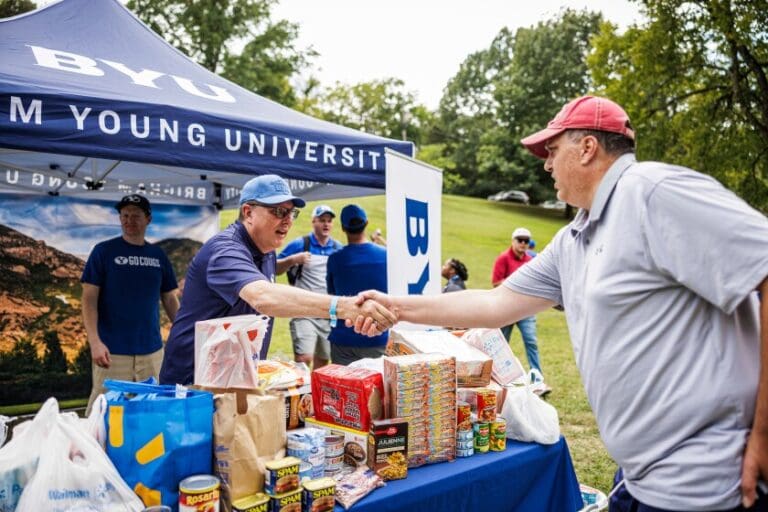BYU fans donate food at a Cougs Care pregame tailgate, supporting local charities and nonprofits.