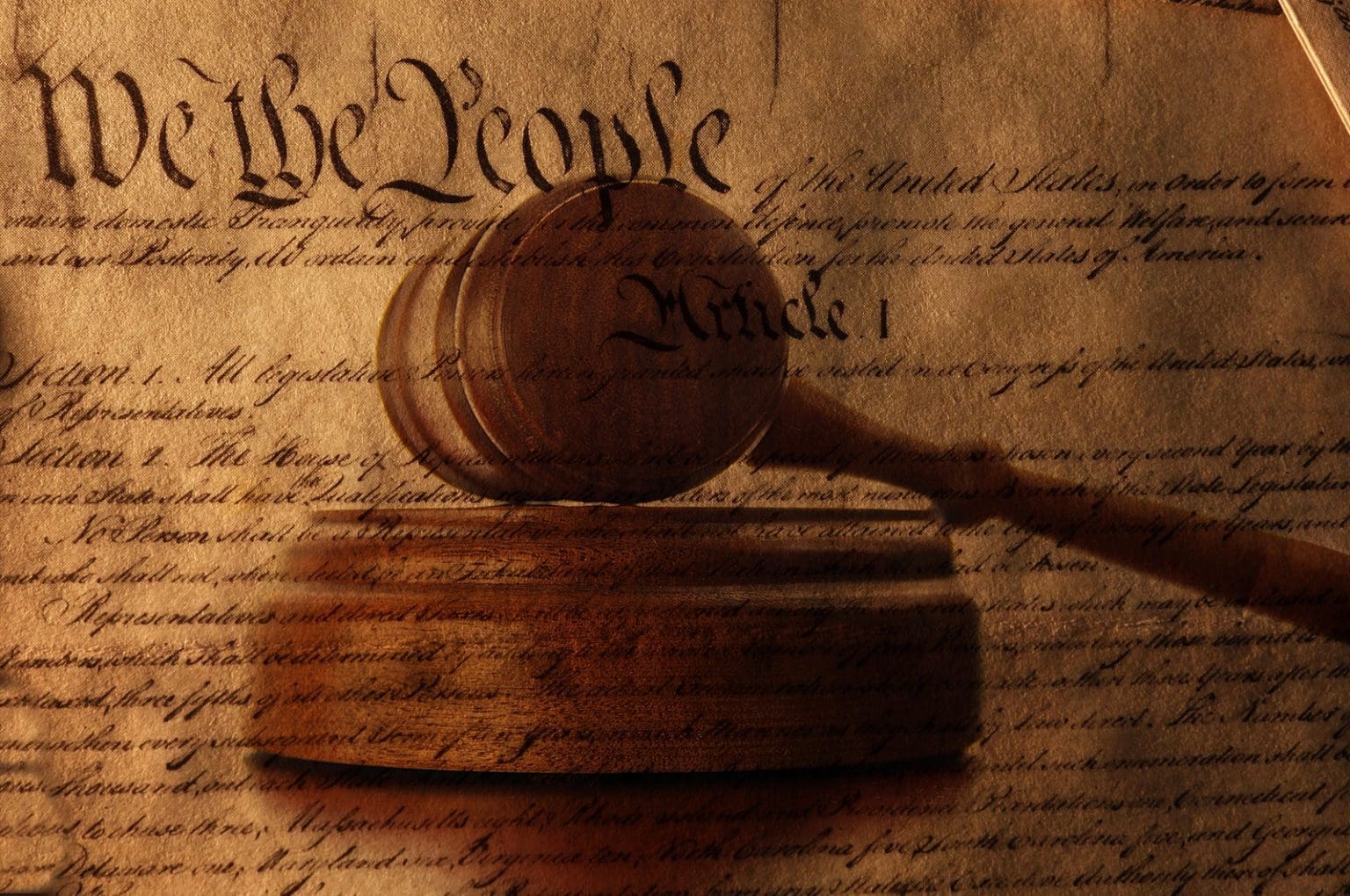 Gavel on the U.S. Constitution with the words "We the People" in focus, symbolizing the importance of constitutional preservation and civic education.
