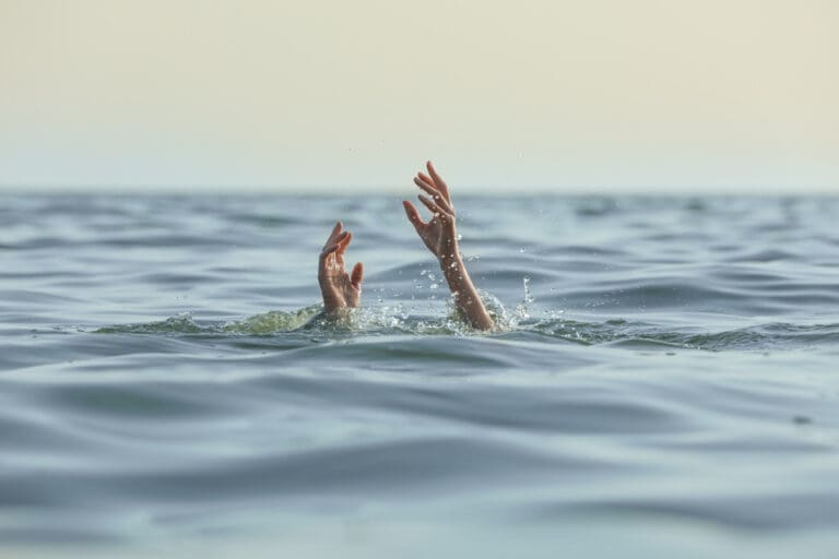 Hands reaching out of water, representing faith and reliance on God during life's difficult trials