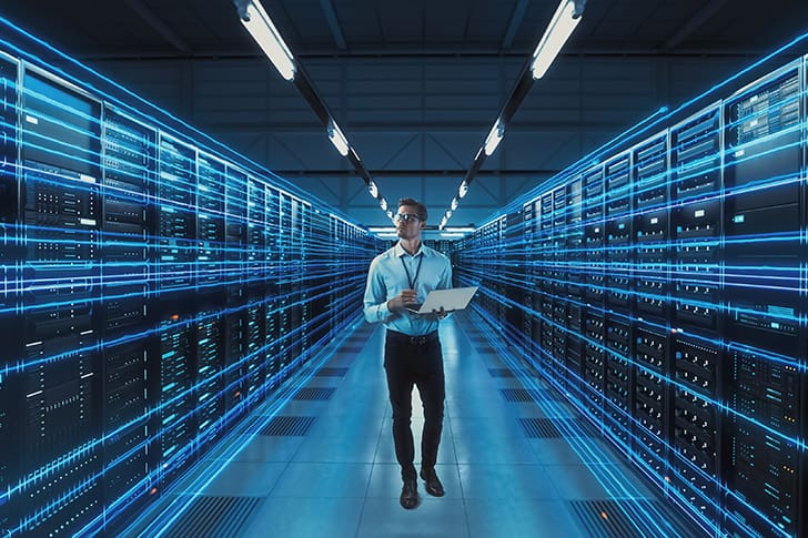 A man working in a futuristic server room representing the technological backbone of Meridian Magazine’s operations.