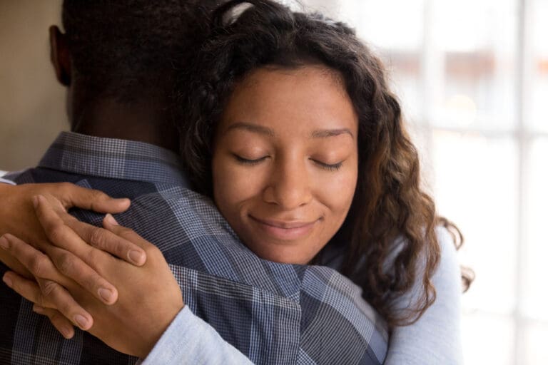 Woman embracing her partner, representing emotional safety and rebuilding trust in relationships after betrayal and trauma.