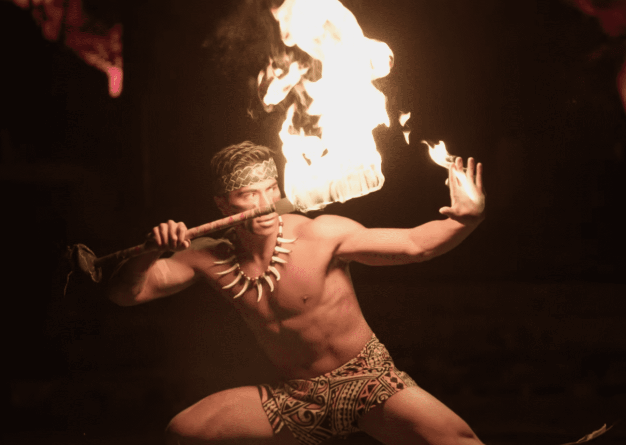 Polynesian fire dancer performing with flaming baton at the Polynesian Cultural Center.