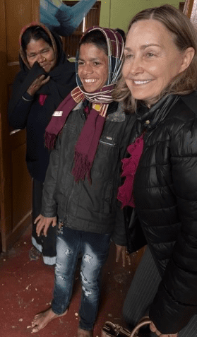 Becky Douglas shares a joyful moment with children at Rising Star Outreach, highlighting the life-changing impact of child sponsorship.