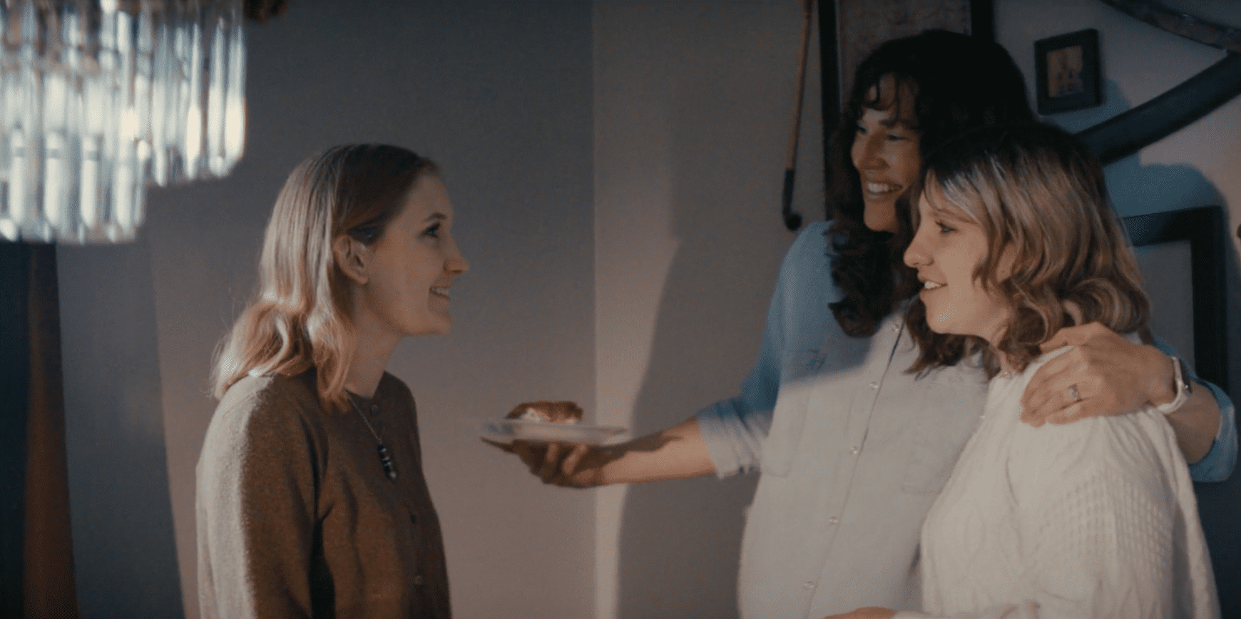A warm baby shower scene from Two Heartbeats, showing women laughing, sharing stories, and supporting one another through life’s transitions.