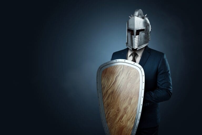 A man dressed in a suit with a medieval knight’s helmet and a wooden shield, representing the armor of God and spiritual warfare.
