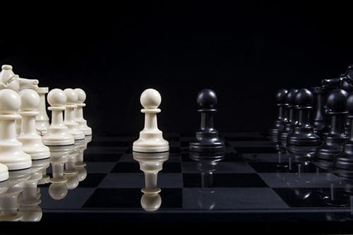Chessboard with black and white pawns facing off, symbolizing marital conflict and the need for communication and connection in relationships.