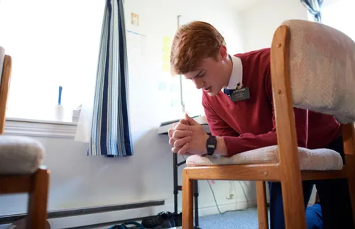 Missionary kneeling in prayer for strength and mental resilience.