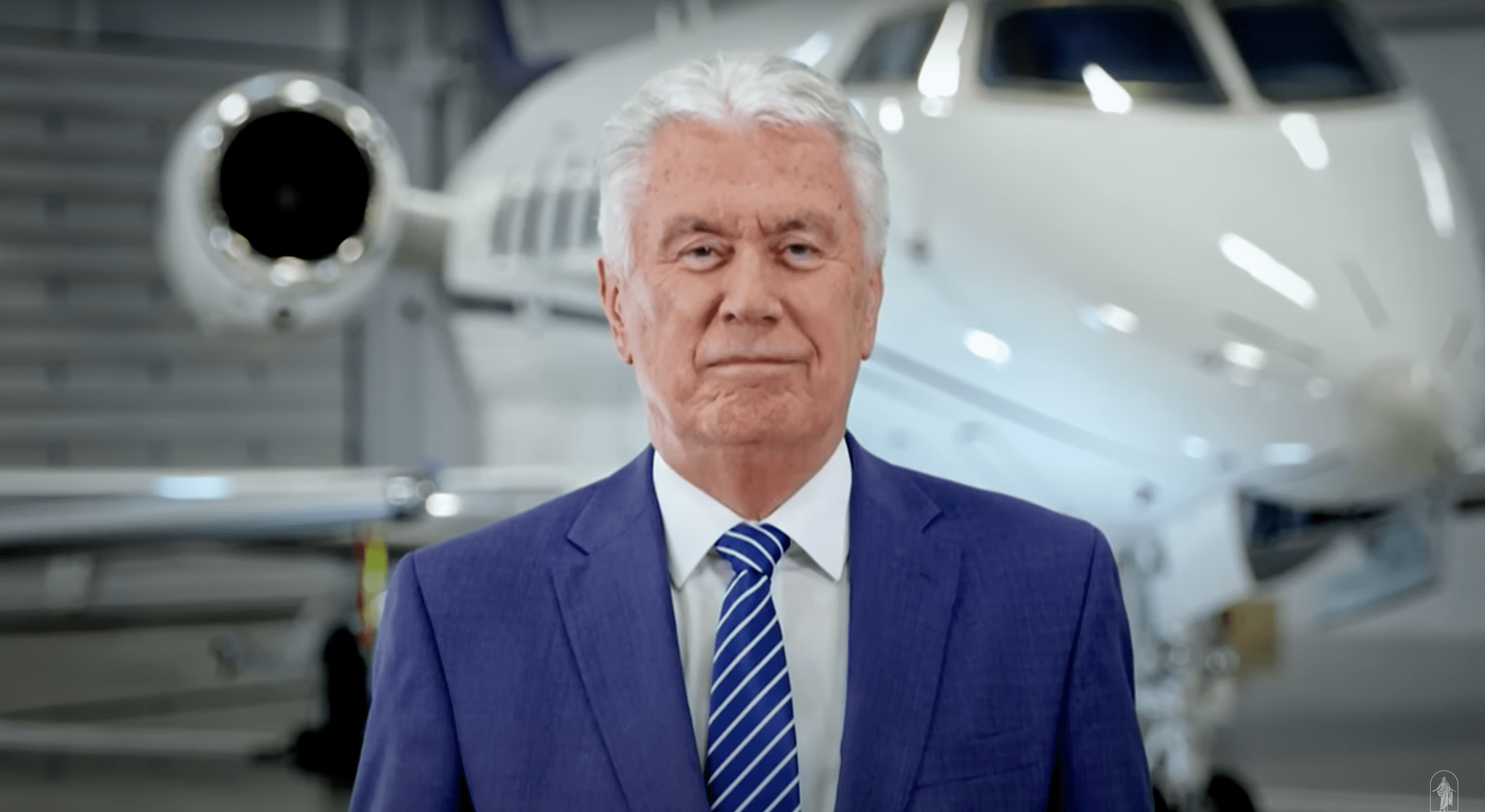 Elder Dieter F. Uchtdorf in front of an airplane, sharing a message of faith, perseverance, and God’s love in overcoming life’s challenges.