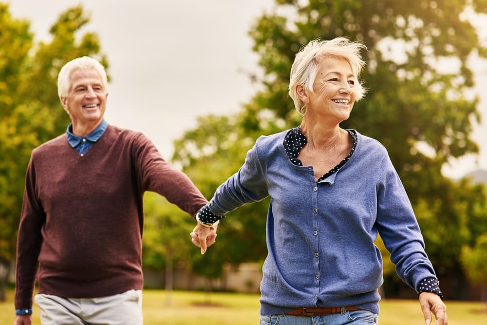 Happy senior couple walking in park, symbolizing joy and purpose in the second half of life