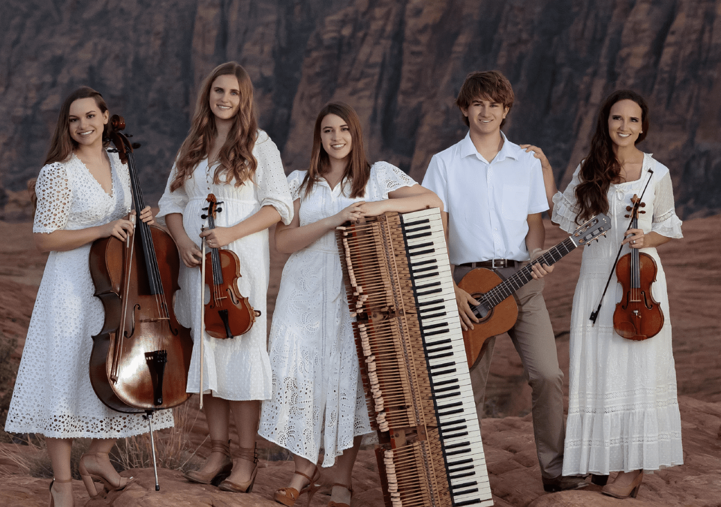 Jenny Oaks Baker and Family Four pose with musical instruments in the red rocks of Utah for their American Mosaic patriotic concert.