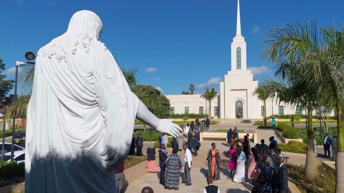 Latter-day Saints gather at the Nairobi Kenya Temple dedication in front of a Christus statue, symbolizing faith and temple blessings in East Africa.