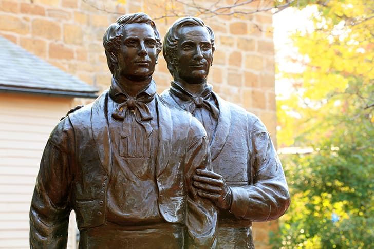 Bronze statue of Joseph and Hyrum Smith standing together outside Carthage Jail, commemorating their brotherhood and joint martyrdom.