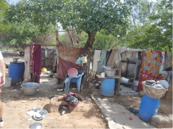 Makeshift outdoor bathroom structures in an Indian leprosy colony showing lack of sanitation, dignity, and safety before service-based improvements.