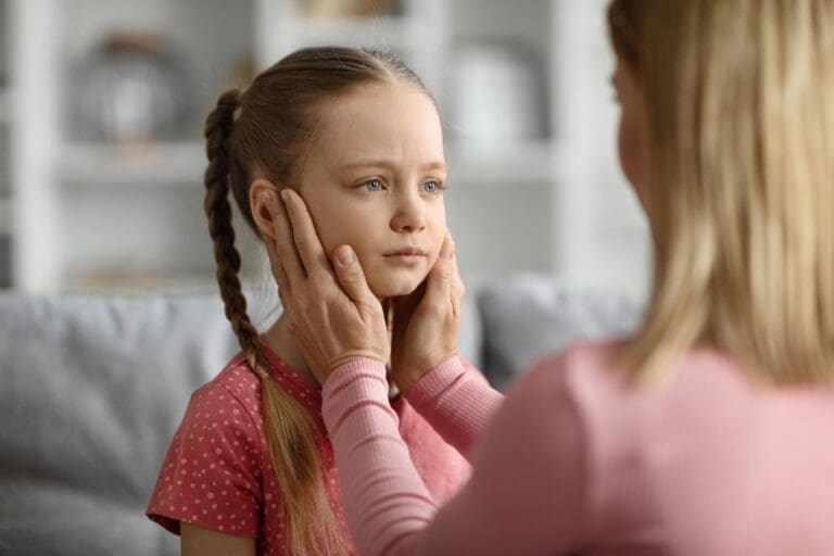 Mother teaching calmness to young daughter through courageous parenting.