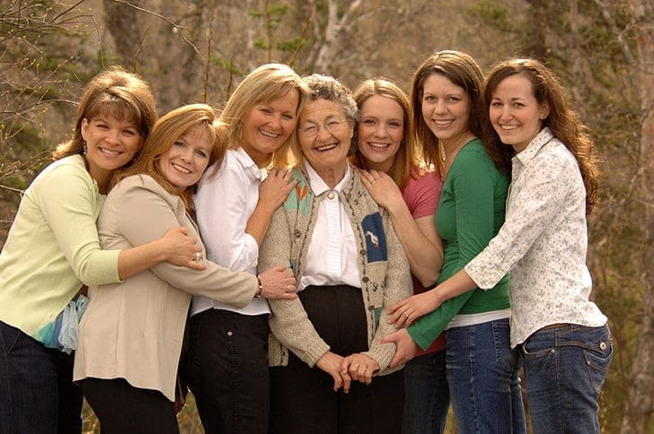 Latter-day Saint women of three generations embracing outdoors, representing faithful stewardship and unity from Doctrine and Covenants 81–83.