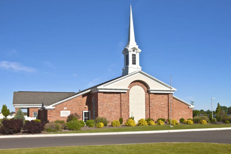 Latter-day Saint meetinghouse with white steeple and red brick exterior