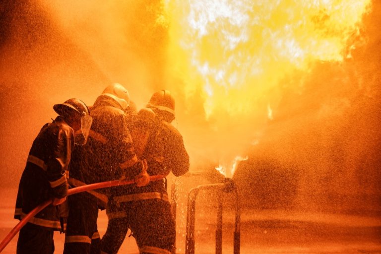 Wildland firefighters battling flames in full gear amid intense fire and smoke