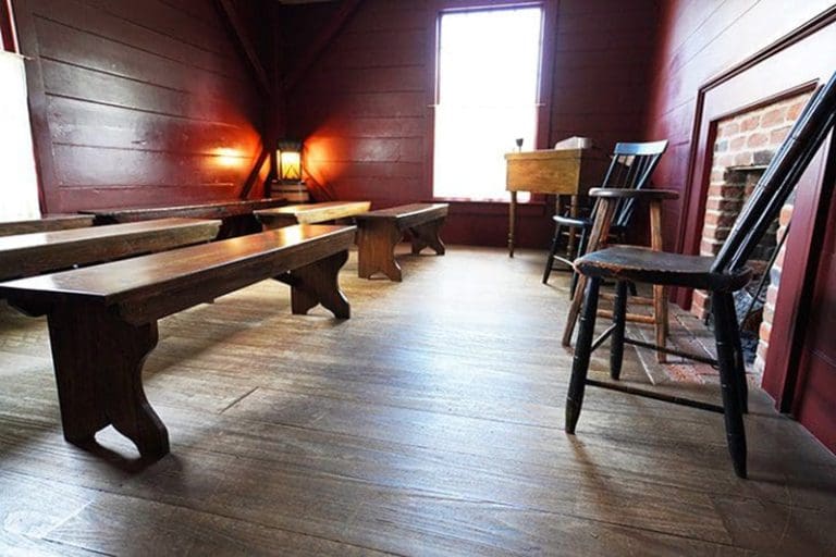 Historic Latter-day Saint meeting room with wooden benches and fireplace, connected to revelations in Doctrine and Covenants 89–92.
