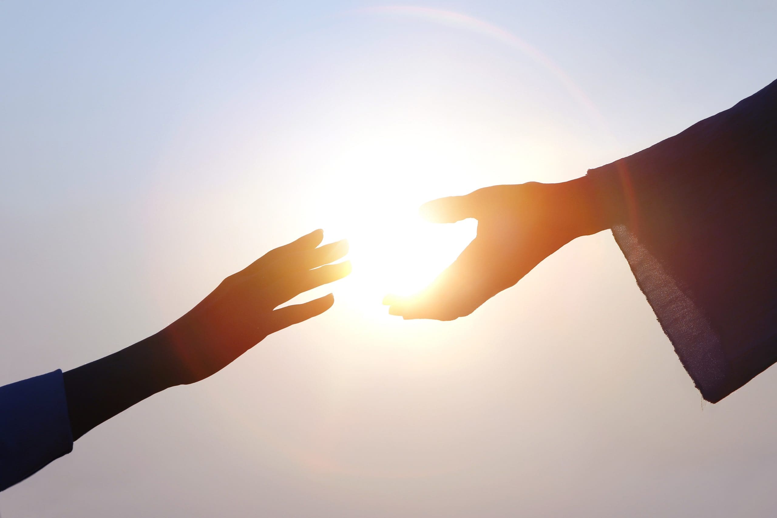 Hands reaching for light symbolizing peace, compassion, and Christlike love after Charlie Kirk’s assassination.