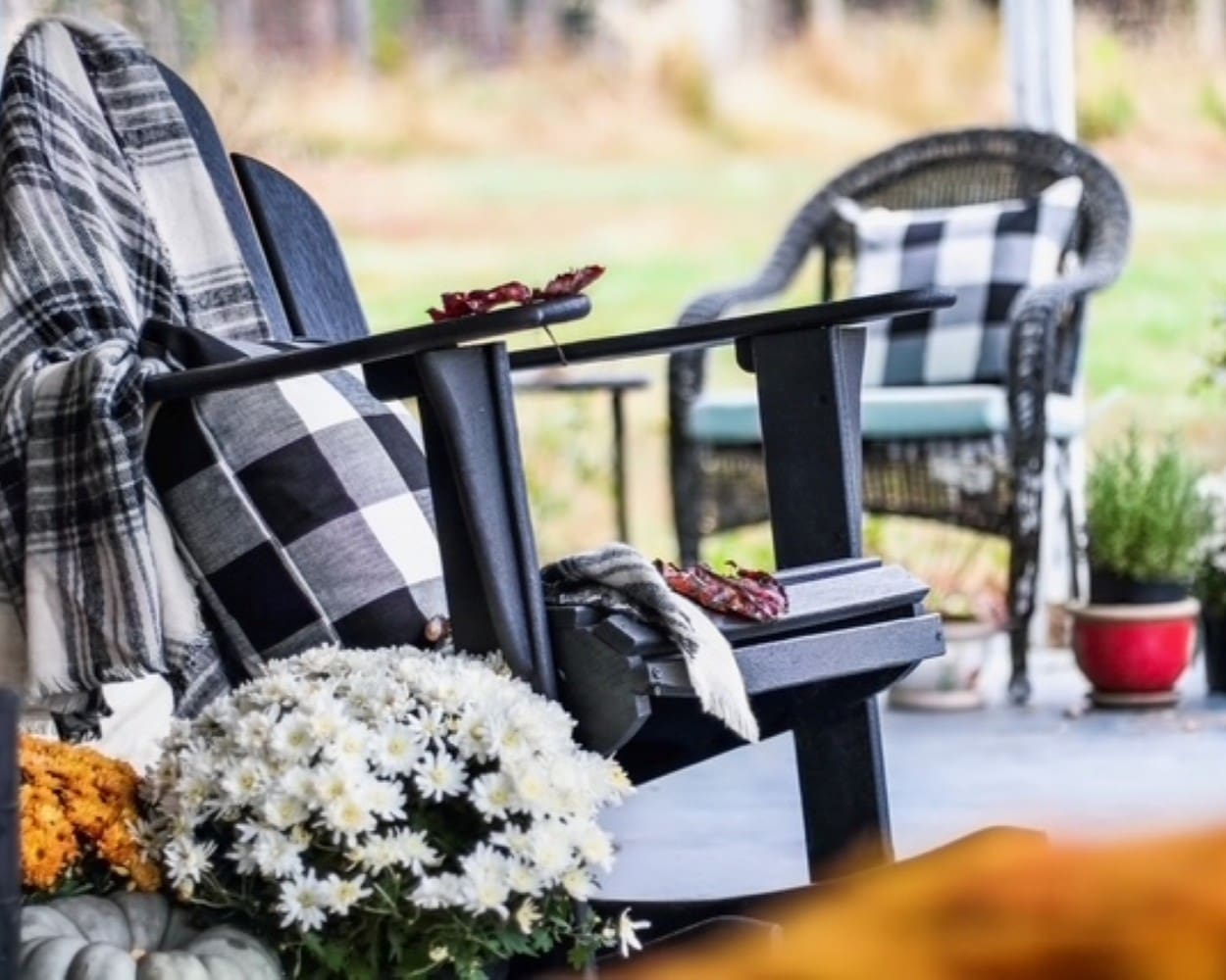 Rocking chair with plaid blanket and autumn flowers, symbolizing resilience and inspiration from Daris Howard’s story Not Sitting in Rocking Chairs.