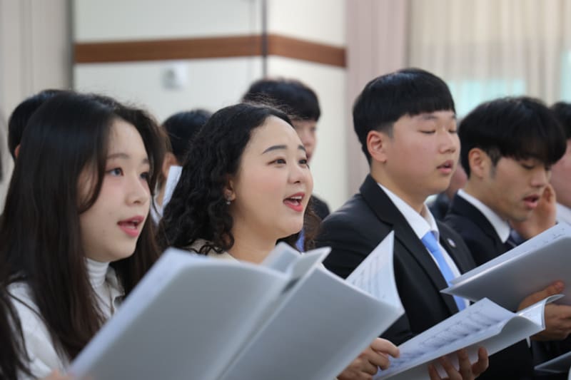Latter-day Saint congregation singing Hymns for Home and Church during worship service.