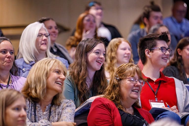 Latter-day Saint creators at the LDSPMA conference listening and smiling during a faith-based publishing and media workshop.