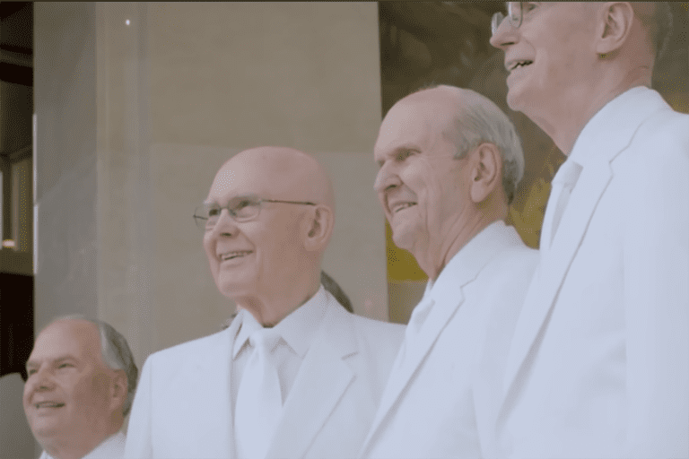 President Dallin H. Oaks with fellow leaders of The Church of Jesus Christ of Latter-day Saints in white temple clothing, symbolizing faith and service.