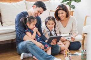 Family using a tablet to join FamilySearch Webinars and explore free genealogy resources together.