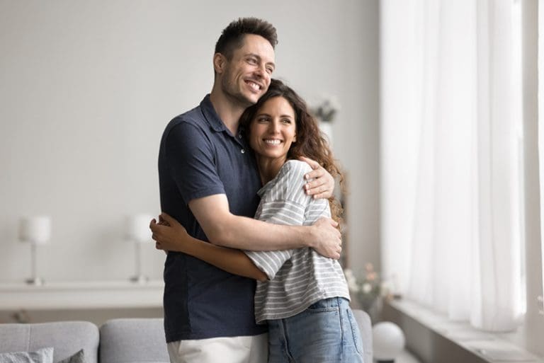 Couple embracing with joy, representing authentic love and vulnerability in relationships built on faith and honesty.