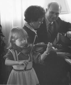 A young Jenny Oaks Baker playing the violin while her parents, including President Dallin H. Oaks, support her early dedication to hard work.