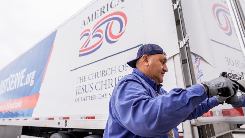 A Church volunteer secures an America250 semi-truck designated for delivering food donations across the United States as part of the Church of Jesus Christ’s nationwide service initiative supporting the 250th anniversary of the Declaration of Independence.