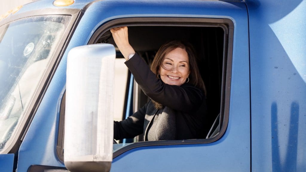 A smiling volunteer sits in the driver’s seat of a JustServe-branded truck supporting the Church of Jesus Christ’s America250 initiative, which mobilizes service efforts across the United States ahead of the nation’s 250th anniversary.