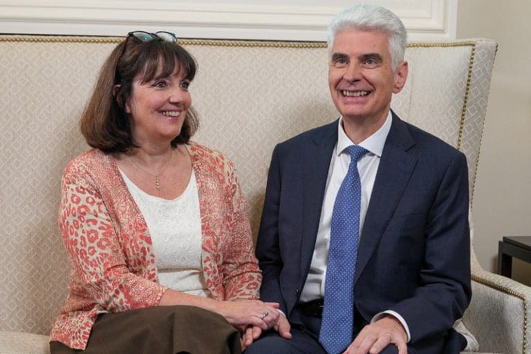 Elder Gérald Caussé sitting with his wife Valérie Caussé after being called to the Quorum of the Twelve Apostles.