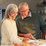 Older couple preparing Thanksgiving meal together, illustrating Debts of Gratitude, Thanksgiving gratitude, and appreciating family blessings.