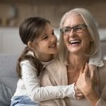 Grandmother laughing with her young granddaughter, symbolizing grandparent love and the powerful bond between generations.