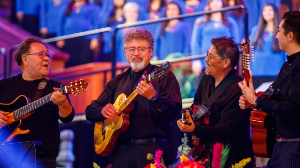 Musicians play guitars on stage at Luz de las Naciones 2025, part of the Church of Jesus Christ of Latter-day Saints’ annual Latino cultural celebration in Salt Lake City. The event, themed Peace That Shines, highlights unity through music and faith.
