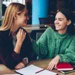 Two friends talking with warmth and support, illustrating staying connected when friends leave the Church despite faith differences.