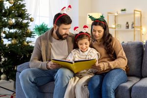 Family reading Christmas children’s books together, enjoying Christmas picture books and a meaningful Christmas read-aloud about faith and the true meaning of Christmas.