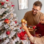 Family decorating a Christmas tree.Family decorating a Christmas tree in celebration of christ, showing Christian joy and a Christ-centered Christmas.
