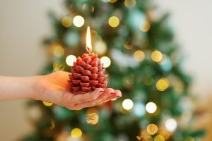 Hand holding a lit candle symbolizing how Meridian Magazine is sustained by voluntary subscribers and faithful readers who help keep its light shining.