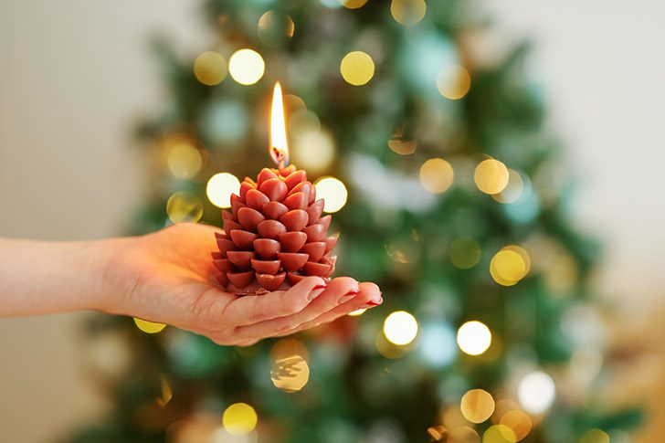 Hand holding a lit candle symbolizing how Meridian Magazine is sustained by voluntary subscribers and faithful readers who help keep its light shining.
