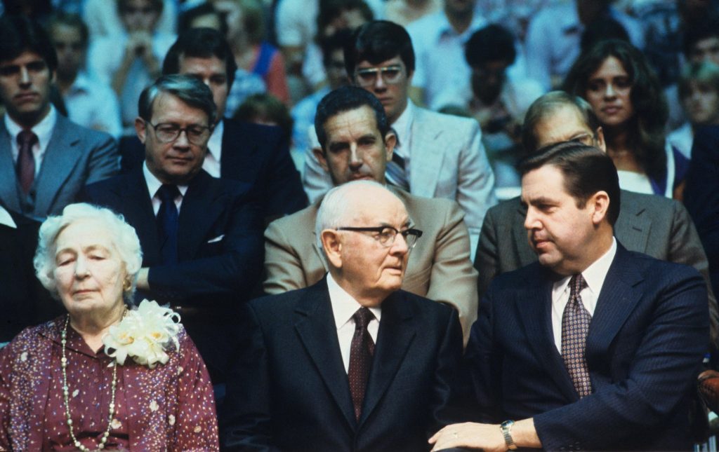 President Jeffrey R. Holland seated among fellow Church leaders and Spencer W Kimble during a historic gathering of The Church of Jesus Christ of Latter-day Saints.